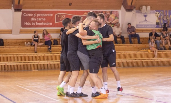 O echipă în negru sărbătorind împreună pe teren